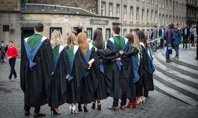 A row of 69ý graduands standing in a row wearing their gowns outside Usher Hall